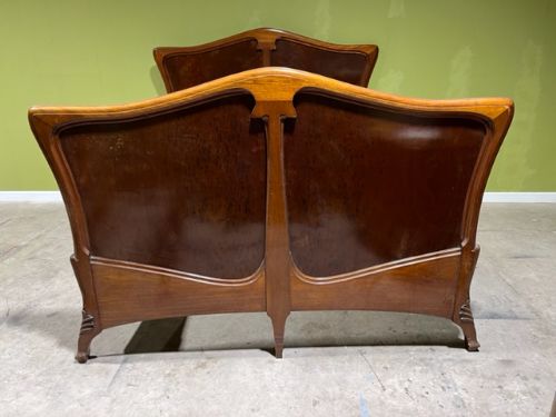 an art nouveau plum pudding mahogany bed